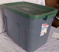 Rubbermaid 18 gallon storage tote with green lid, showing full tote and lid from side angle