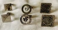 Three pairs of cufflinks arranged in two rows showing front face designs: maple leaf, Mayan calendar, and geometric.