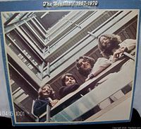 Front cover of the double album vinyl showing The Beatles looking down a building balcony.