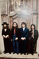 Album front cover photo of The Beatles standing against wooden background