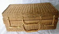 Front view of vintage wicker sewing/jewelry box showing rectangular shape, woven wicker texture, two handles, and bamboo latches.