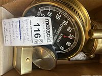 Cardboard box containing black-faced Abbeon hygrometer, part of brass travel clock case and Warner desk clock on wood base