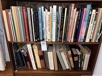 Full view of two shelves filled with books, showing variety of titles and conditions.