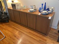 Front view of the buffet cabinet with doors closed and various items on top.