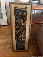Framed Native American style totem pole tapestry textile artwork, vertical orientation on wooden frame with fabric backing