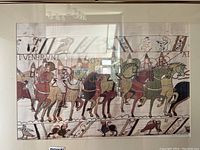 Framed print showing medieval knights on horseback with intricate borders and text.