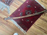 Full-length view of sword sheathed on wooden scabbard