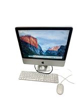 Front view of Apple iMac powered on showing desktop screen with keyboard and mouse on white background.