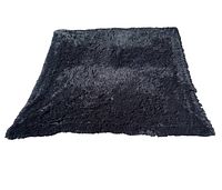 Top-down view of black fluffy carpet showing texture and color blending of black with whit grey undertone.
