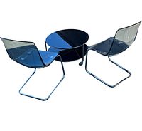 Set of 2 transparent plastic chairs with chrome cantilever frames alongside a round black glass coffee table with wheels, viewed on white background.