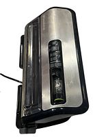 Top angled view of FoodSaver FM5200 automatic vacuum sealer showing brushed stainless steel surface, control buttons, and vacuum mechanism compartment.