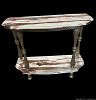 Front angle view of vintage marble console table showing marble top and four ornate metal legs.