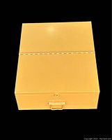 Top view of the closed yellow lock box showing smooth yellow steel surface and front latch.