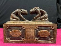 Front view of the wooden carved sliding box showing ornamental inset panels