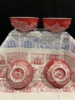 Two of the crystal glazed bowls with white petal-like crystalline decoration on red base, showing side and bottom views