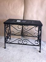 Front and side views of the heavy iron plant stand showing rectangular top and decorative scrollwork on all sides.