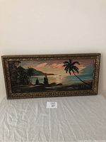 Vintage oil painting framed, depicting tropical sunset landscape with palm trees, water and colorful sky. Signed by Marvin in lower left.