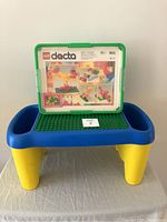 Wide shot of the vintage Lego Duplo lap table with the Lego Dacta 9651 box and instruction set on top, showcasing the full setup with bright primary colors.