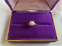 Ring displayed in purple velvet jewelry box.