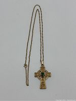 Full 18-inch gold chain with attached Celtic cross pendant laid flat against white background