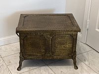 Full front view of the antique brass coal scuttle showing hammered finish and brass legs