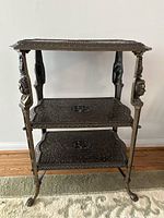 Full frontal view of three-tier shelf showing overall structure and bust supports