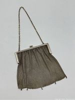 Full view of antique sterling silver mesh evening bag with chain strap laid flat on white background to show overall size and shape.