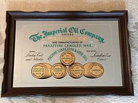 Full view of the framed mirror advertising Imperial Oil Company products showing text and barrel graphics on reflective surface.