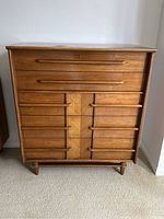 Front view of entire walnut chest, shows 5 drawers and integrated handles
