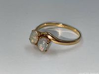 Oblique angle on white background showing two oval opals and bypass shank