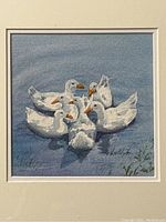 Close-up view of the watercolour painting depicting seven white ducks with orange beaks in a pond, signed by artist 'Louttit 91'