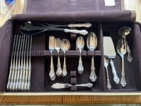 Overview of all flatware pieces arranged in the wooden, felt-lined case