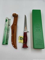 Overview of all lot contents: knife, sheath, box, manual and warranty tag