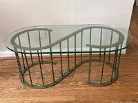 Angled front view showing S-shaped base with twisted spindles and clear glass top