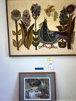 Fabric framed art with flowers and bird hung on wall with framed garden tea scene below it