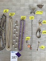 Overview of five necklaces and mixed metal pendants, brooches and charms