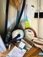 Overview of vacuum, robot box, clock, and cleaning tools against wall