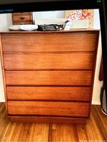 Front view of mid-century wooden dresser with five horizontal drawers