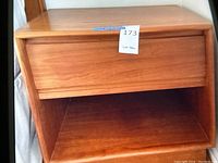 Front view of the mid-century wooden side end table showing the single drawer and open shelf below.