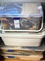 Four stacked plastic containers holding assorted sewing fabric pieces and swatches.