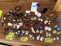 Overhead shot showing full assortment of clip-on earrings arranged on wood surface