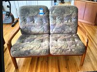 Front view of the wooden love seat couch with cushions showing the seat and back upholstery pattern.