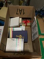 Box containing multiple small jewelry boxes with costume jewelry items inside.