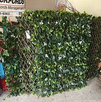 Front view of assembled trellis panels showing dense green foliage and white rose accents