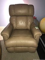 Front view of a brown leather La-Z-Boy recliner chair showing cushioned seat, backrest, and armrests with visible wear and soiling.