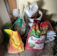 Full view of lawn and garden supplies, includes multiple bags of soil, fertilizer, and plastic container.
