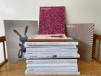 Photo showing a stack of 15 auction catalogues mostly from Sotheby's and Christie's, relating to modern and contemporary art.