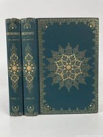 Two green full leatherbound volumes with intricate gilt decorative floral designs on covers and spines, titled 'Constantinople' by De Amicis, showing volume 1 and 2.