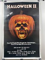 Front view of the Halloween II movie poster showing a skull carved inside a pumpkin with text details.