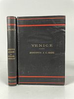 Front covers and spine of the two hardcover travel guides 'Venice' and 'Florence' showing black covers with red lines and gold text.